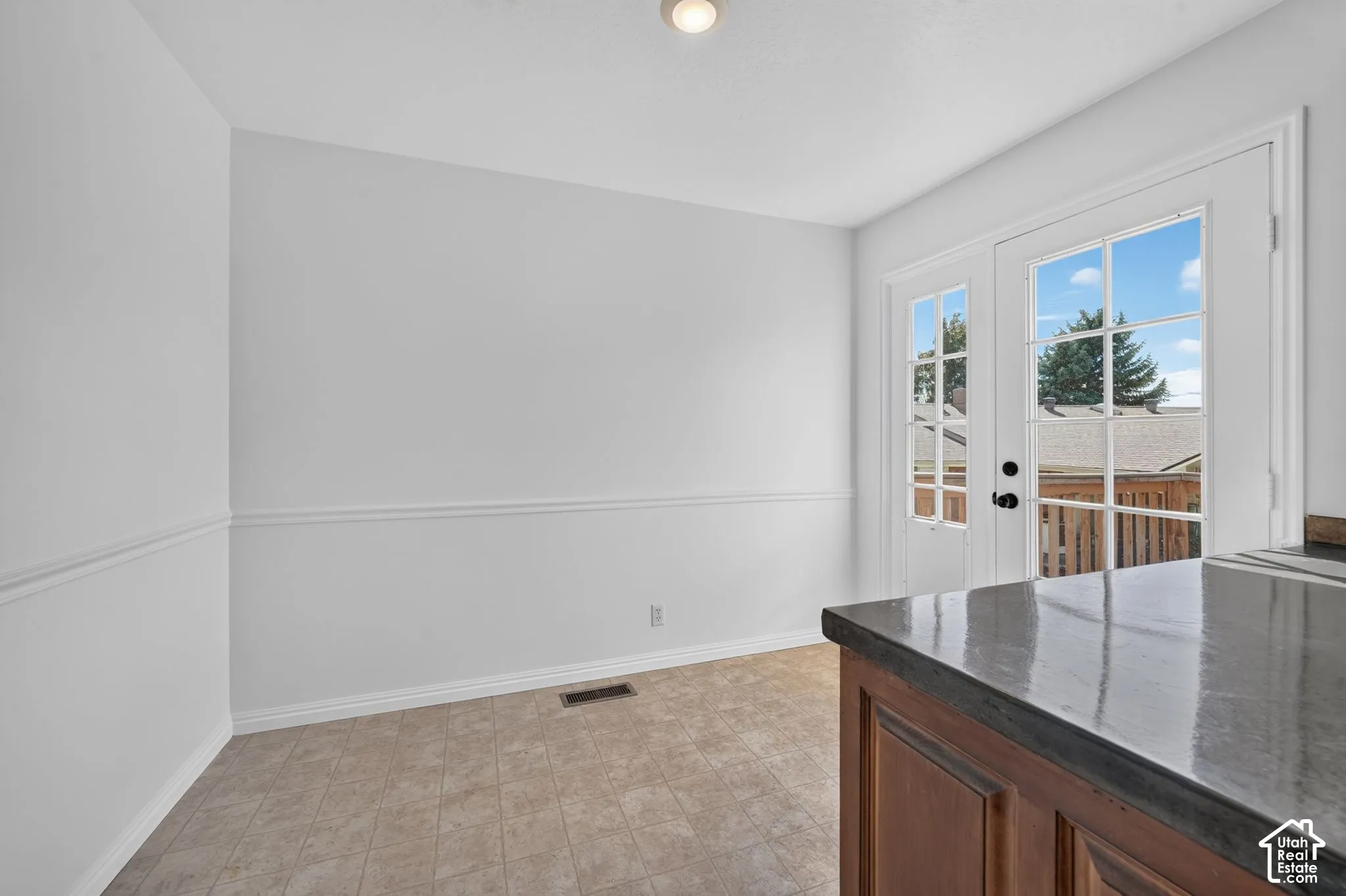 Room featuring chair rail molding, tiled flooring, and a glass-paneled door