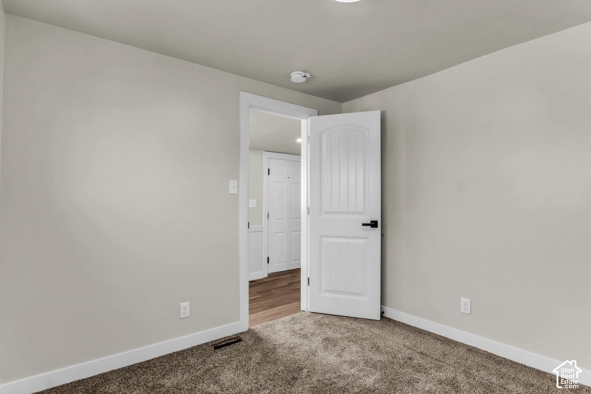 Neutral wall color, recessed lighting, and carpeted flooring