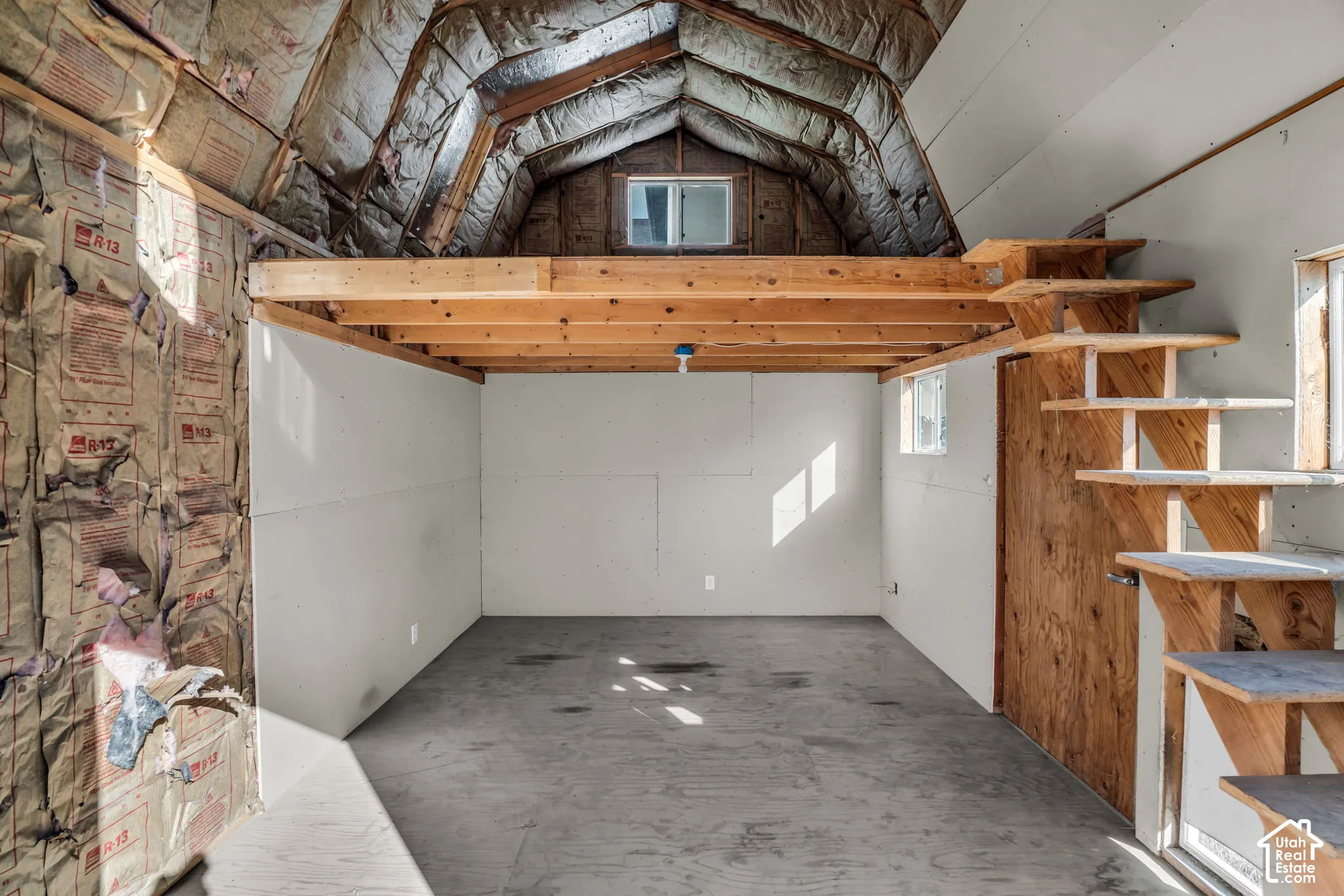 Vaulted ceilings with exposed wood beams, wood-finish flooring, interior loft space, and built-in wood stairs