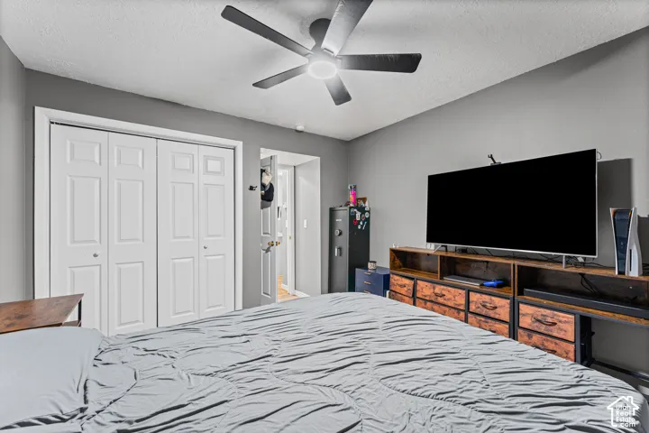 Room featuring neutral-toned walls, ceiling-mounted light fixture with fan, and a dual-panel closet with white trim