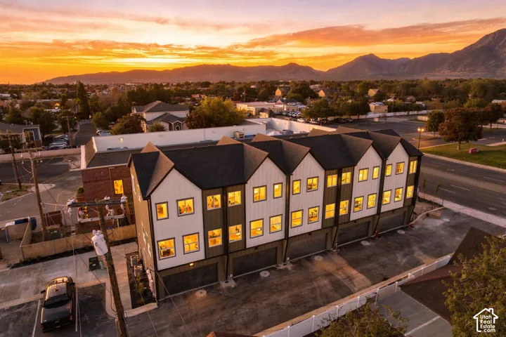 Contemporary townhome-style residences featuring multi-story design, attached garages, and a paved parking area