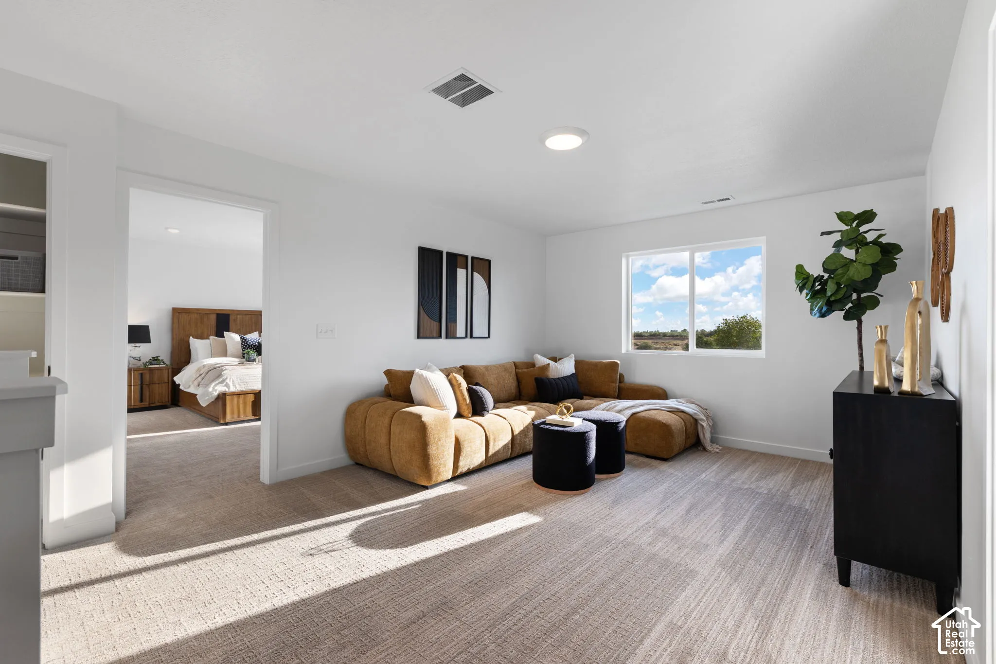 Neutral-toned wall-to-wall carpeting, white interior walls, and a multi-pane sliding window