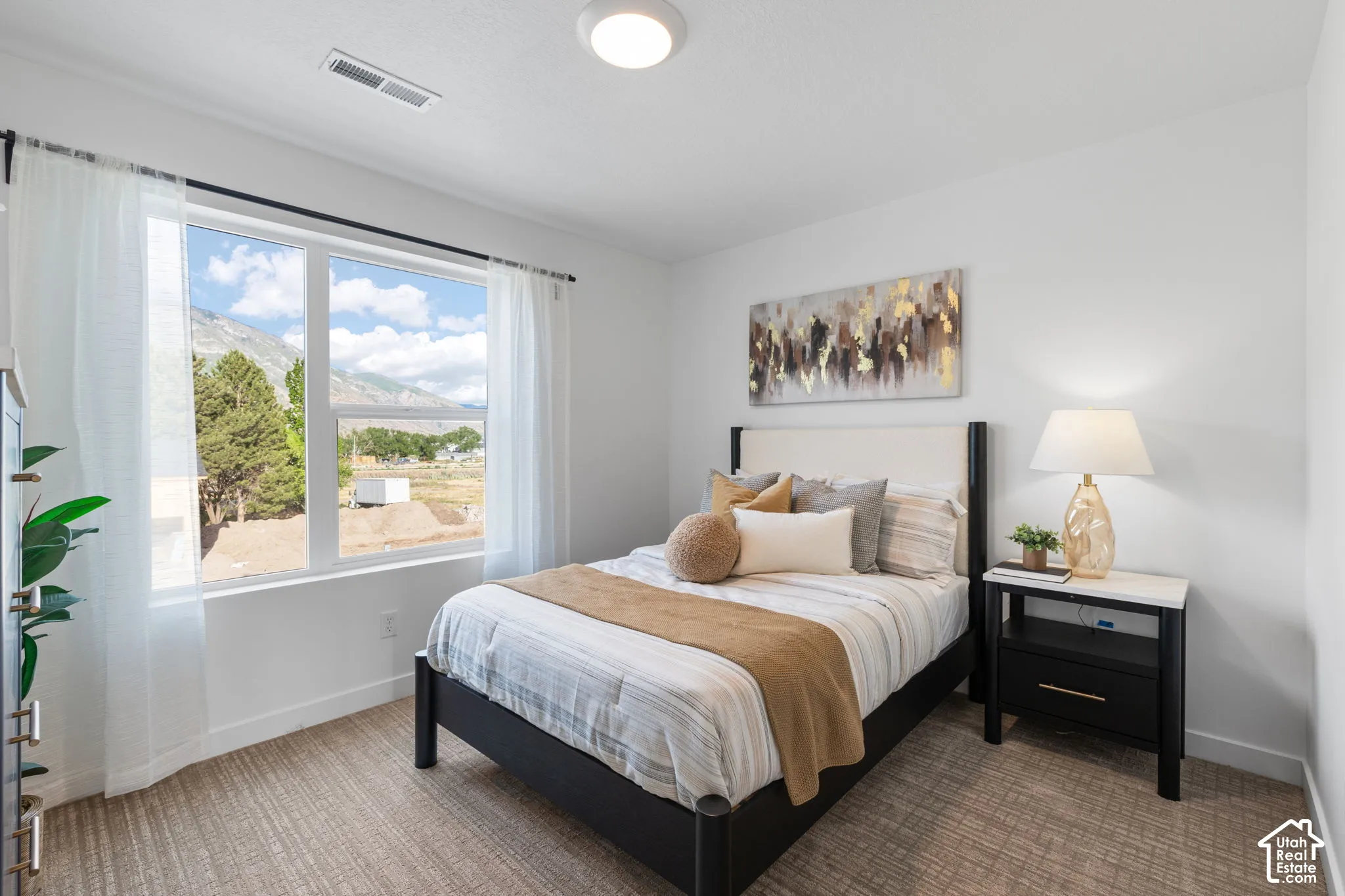 Neutral-toned carpeting, large window featuring mountain and landscape scenery, and flush-mount ceiling lighting