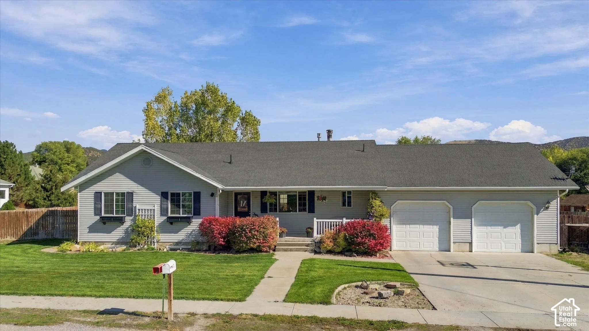 Single-level residence featuring horizontal lap siding, a dual-car attached garage, window shutters, and a concrete driveway