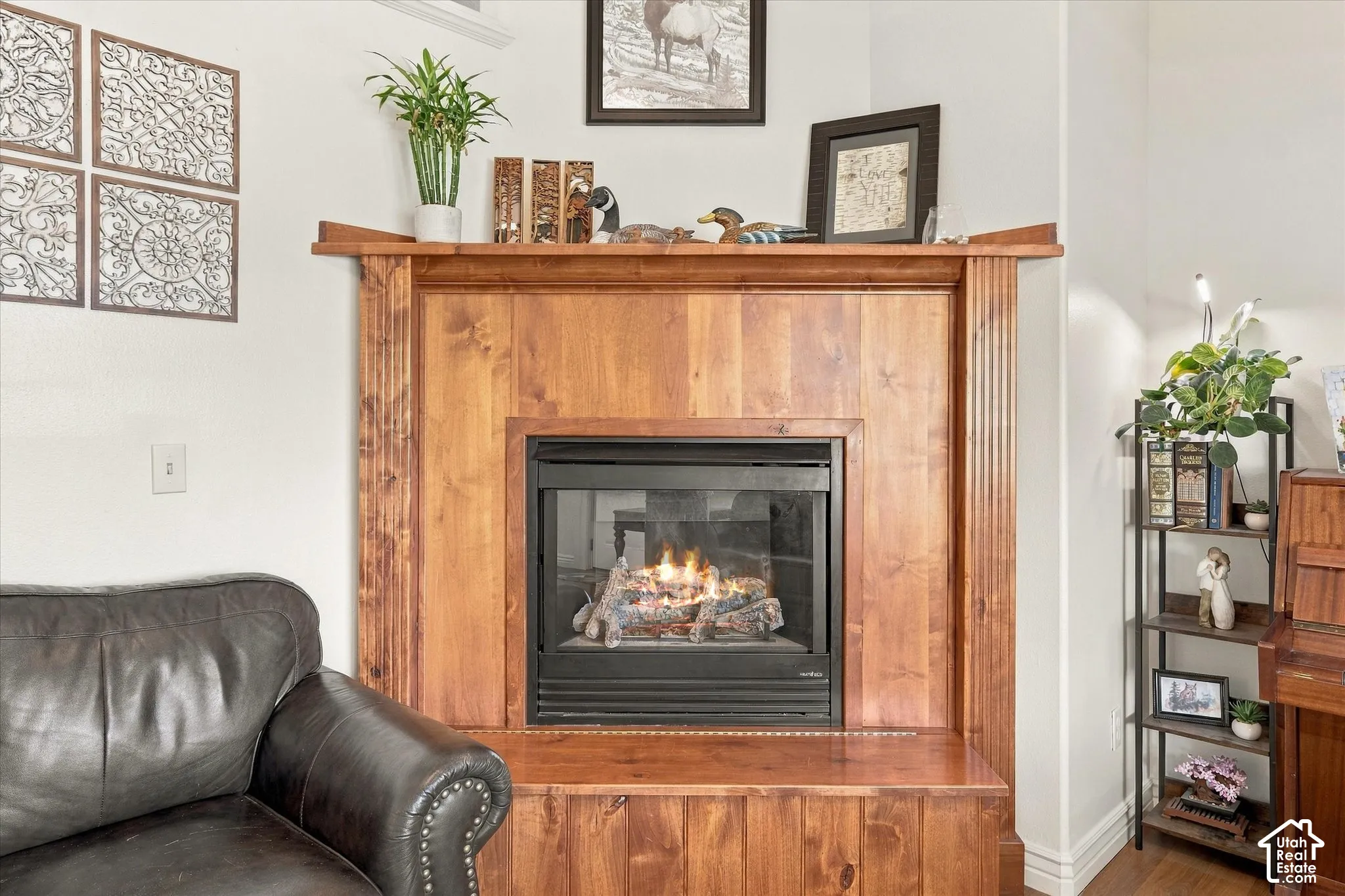 Corner fireplace featuring natural wood-finish surround, mantel, and hearth