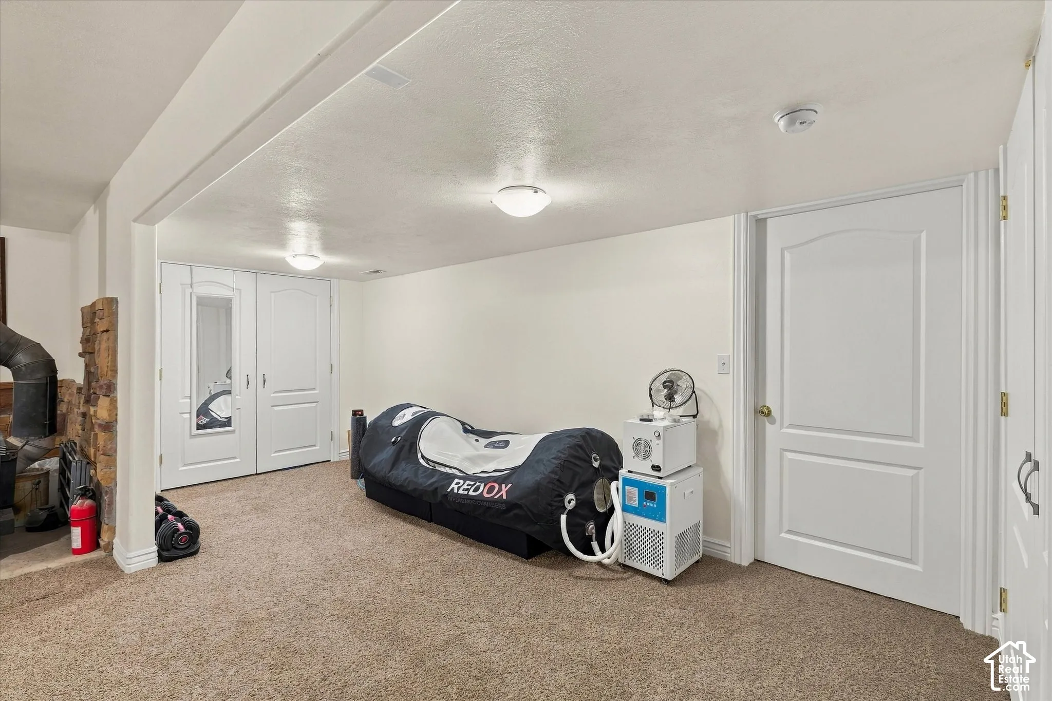 Interior space featuring wall-to-wall carpeting, two-panel arched interior doors, recessed lighting, and a natural stone-faced feature wall