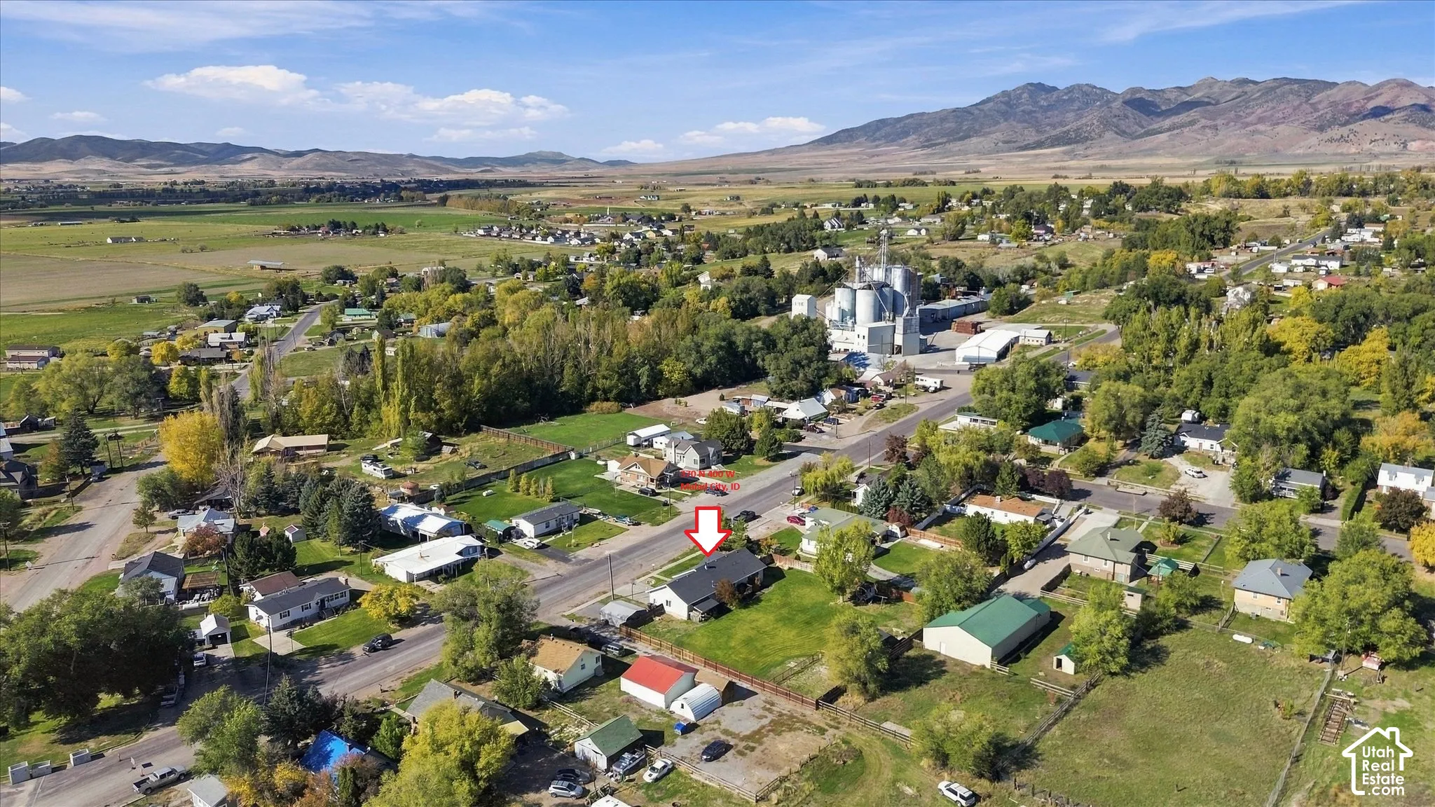 Aerial perspective of residential property featuring a manicured lawn and expansive mountain surroundings