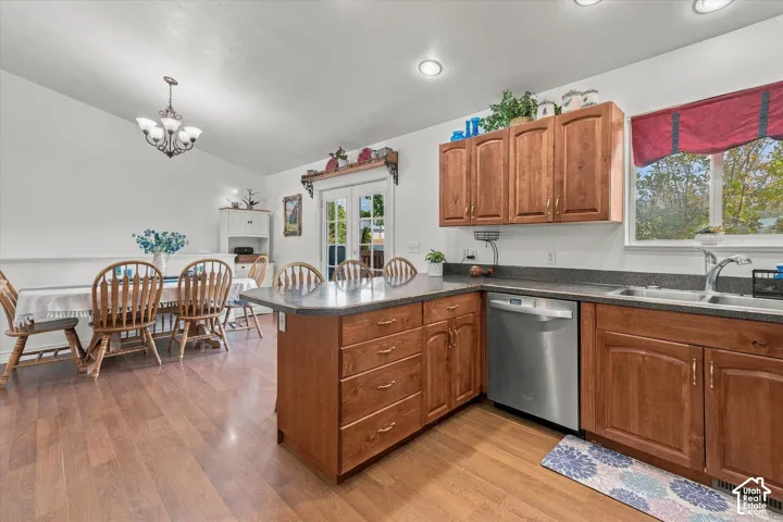 Kitchen featuring wood cabinetry countertops, stainless steel dishwasher, wood-finish flooring, and recessed lighting