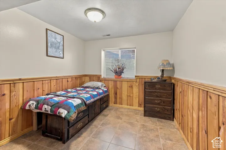 Interior space featuring wood-panel wainscoting, tile flooring, a recessed window, and a flush-mount ceiling light fixture