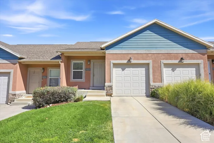 Exterior featuring stucco and stone veneer siding, dual-toned horizontal accent cladding, concrete driveways, and attached multi-car garages