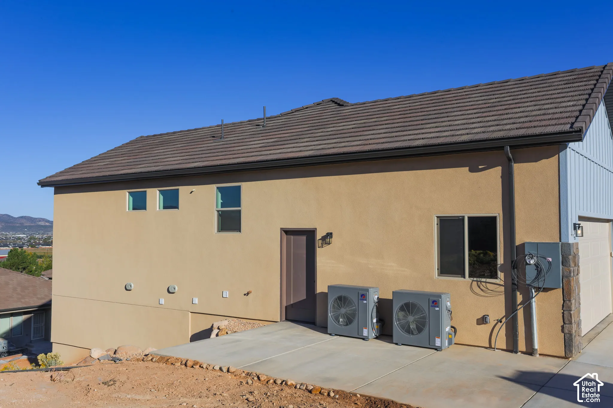 Exterior features include a stucco finish, tile roof, concrete patio, and dual HVAC units