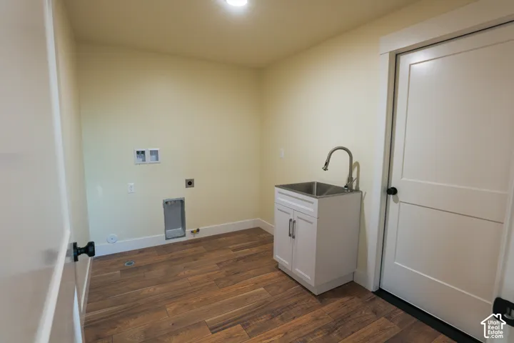 Utility room featuring wood-finish flooring, white Shaker-style cabinetry, a stainless steel basin, and a gooseneck faucet