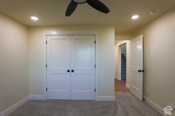 Interior room featuring neutral carpeting, double-panel closet doors, a ceiling fan, and recessed lighting