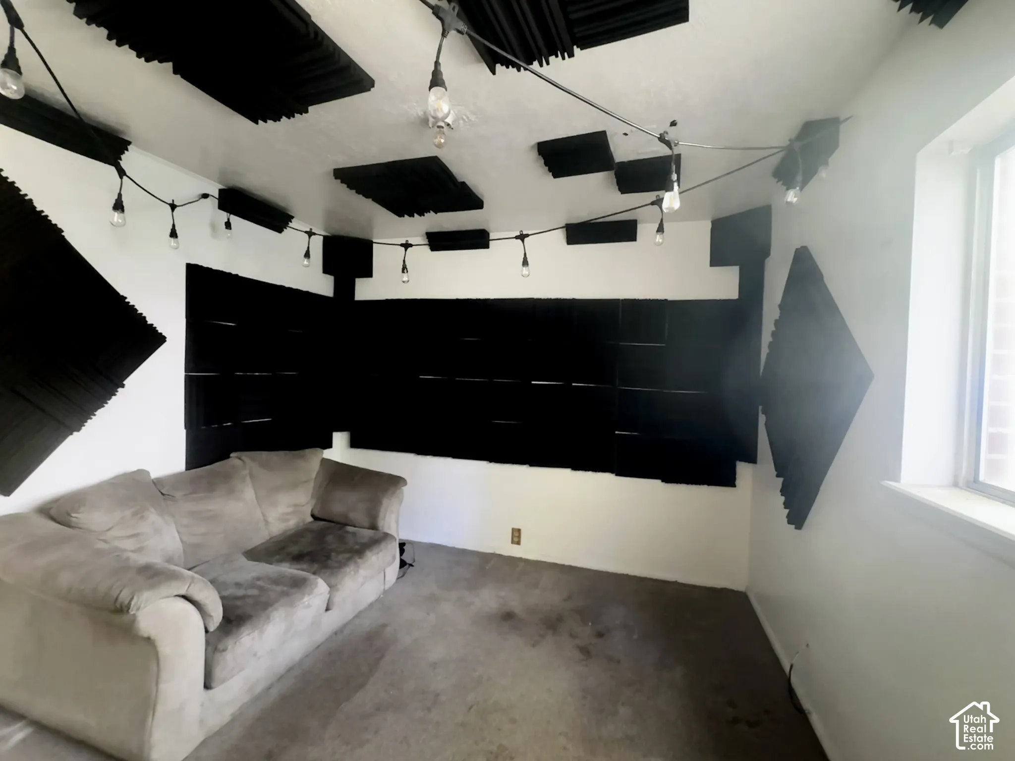 Interior room featuring sound-dampening acoustic wall and ceiling panels, integrated string lighting, and carpeted flooring