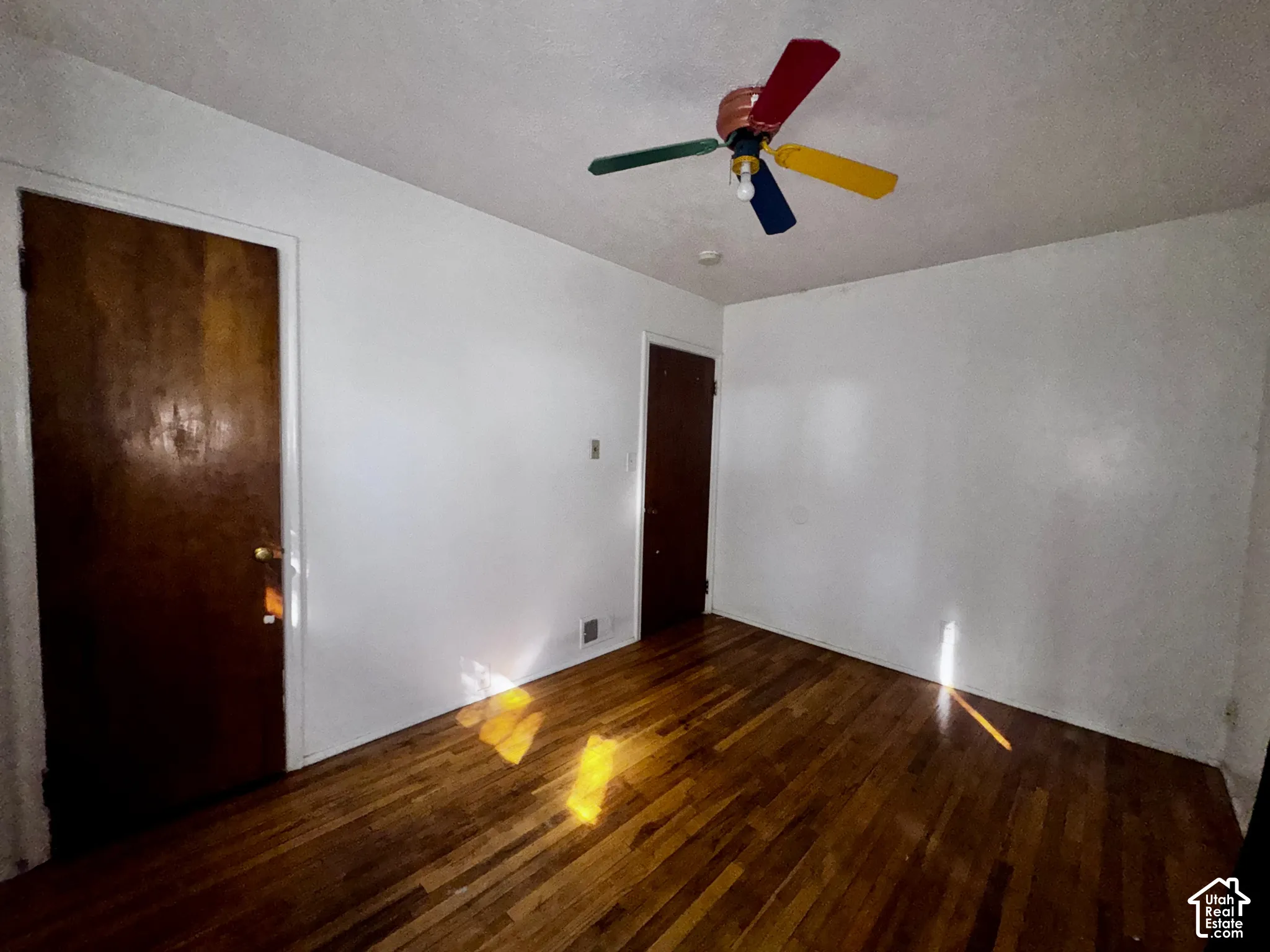 Interior room featuring hardwood flooring and two solid wood-finish doors