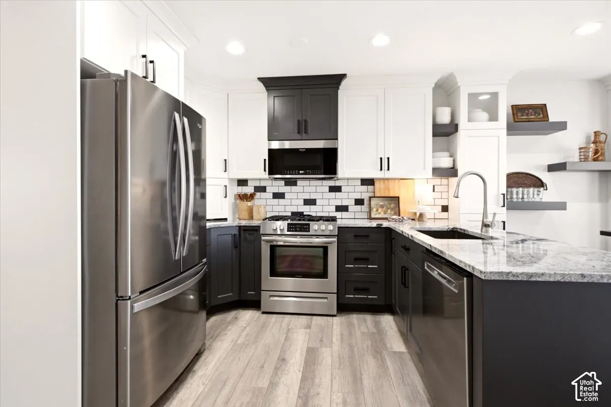 Remodeled kitchen with two-tone cabinetry, stainless steel appliances, updated countertops, and recessed lighting.