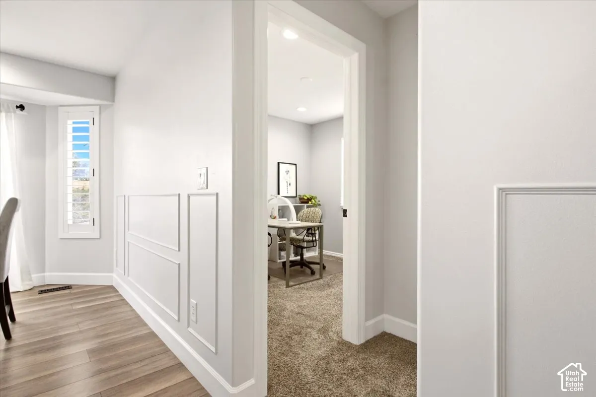 Dining area white walls with decorative wainscoting, recessed lighting, and interior plantation shutters