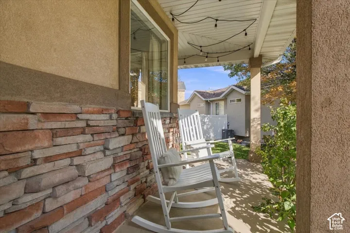 Covered front porch with stone accents and a welcoming seating area in an established Riverton neighborhood.