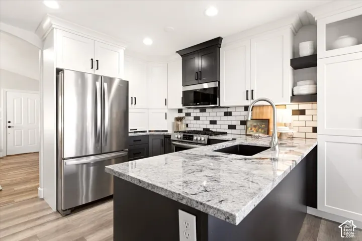 updated kitchen showcasing the center island, contrasting cabinetry, and stainless steel appliances.
