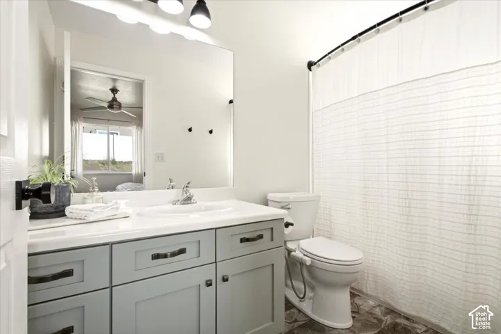 Primary Bathroom featuring a vanity with shaker-style cabinets, countertop-integrated basin, matte black hardware, large wall-mounted mirror, and overhead tri-light fixture