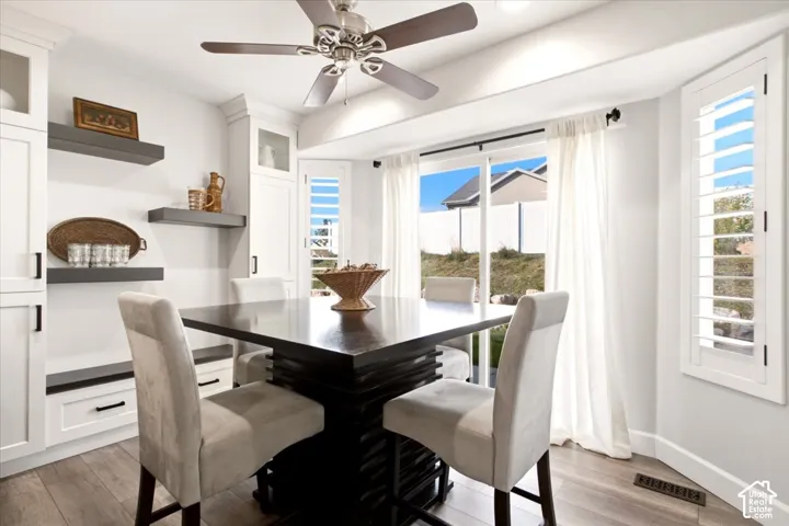 Dining area featuring built-in shelving, updated flooring, and large windows overlooking the backyard.