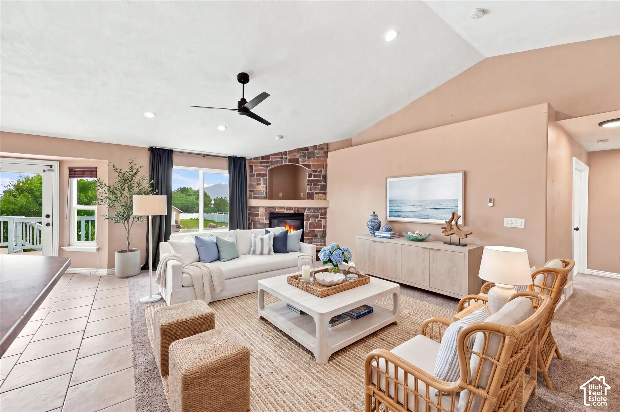 Living area featuring vaulted ceilings, a floor-to-ceiling masonry fireplace with an arched hearth, recessed lighting, and a multi-blade ceiling fan
