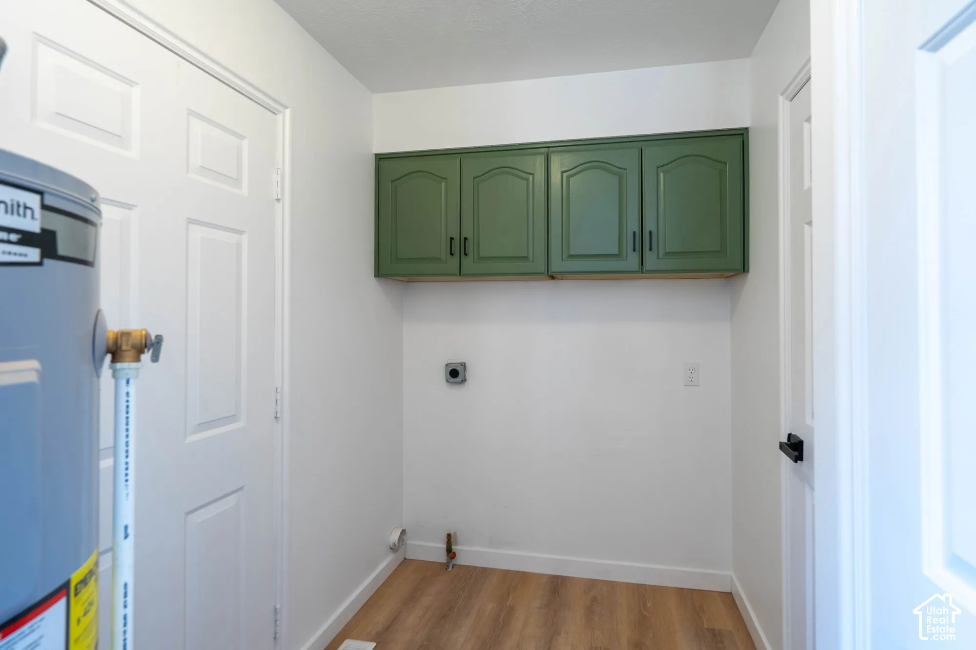 Wall-mounted cabinetry, wood-finish flooring, and white paneled doors