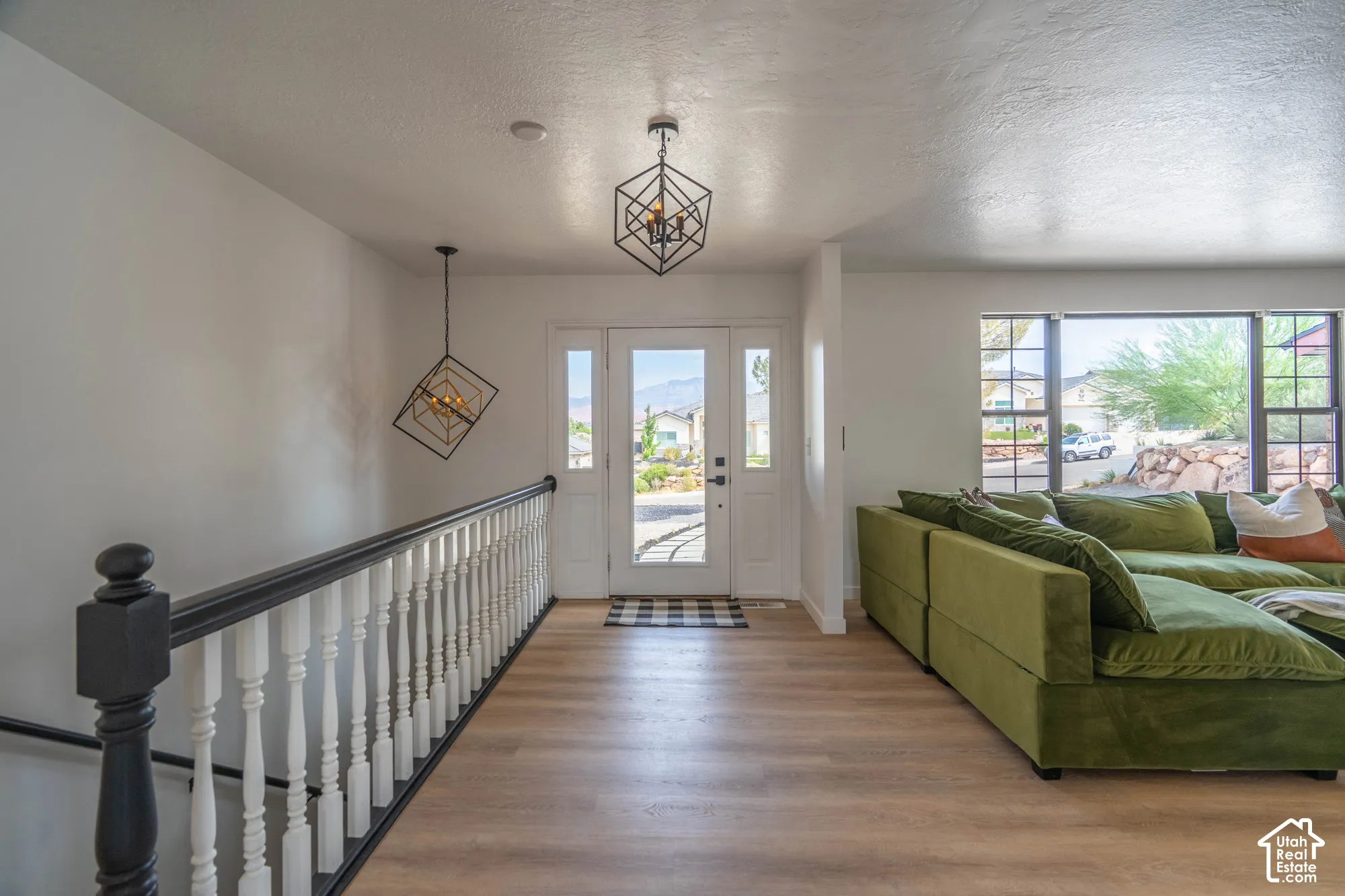 Entryway with wood-finish flooring, a white spindle staircase, and a double-pane glass entry door