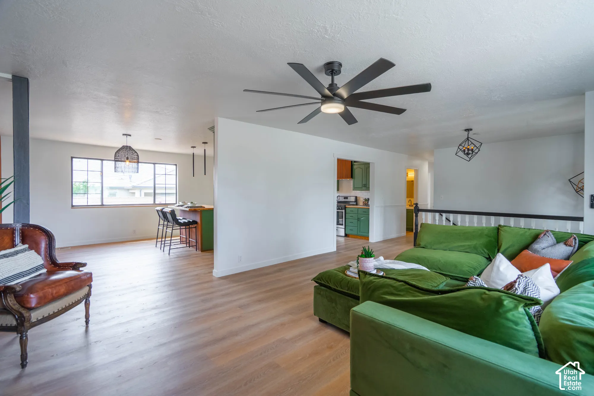 Wood-finish flooring throughout, with a contemporary ceiling fan, and a built-in breakfast bar