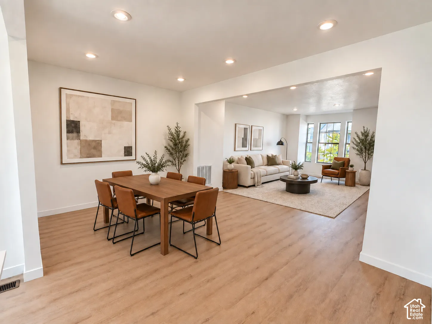Wood-finish flooring, recessed lighting, and large windows providing natural illumination