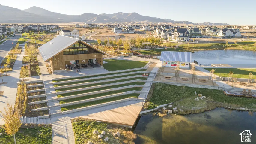 Community grounds featuring a tiered amphitheater, waterfront access, metal-roofed structures, and mountain scenery