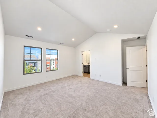 Vaulted ceilings with recessed lighting, wall-to-wall carpeting, and double-paned windows featuring dark trim