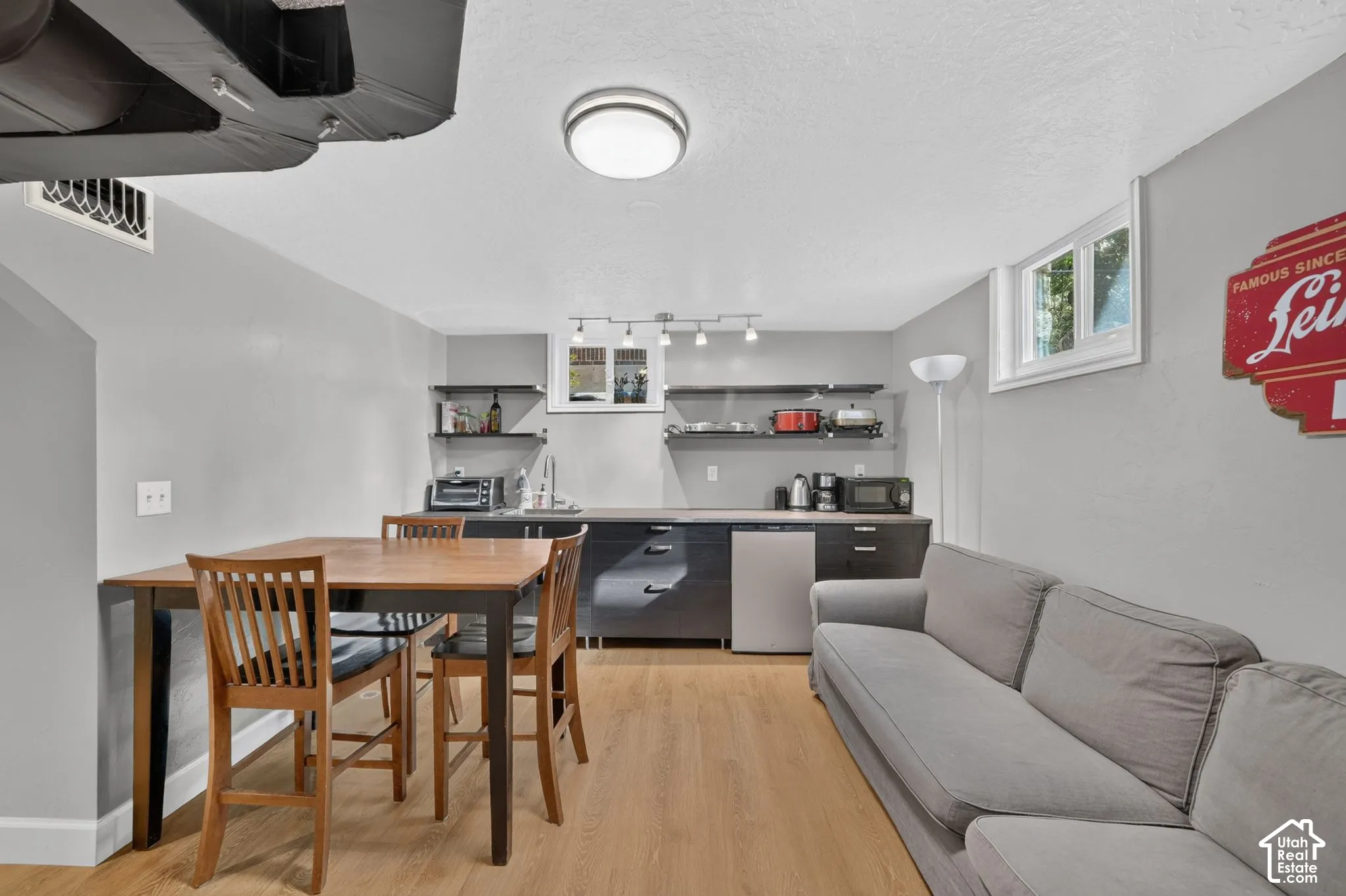 Kitchenette featuring flat-panel cabinetry, open shelving, integrated sink, and wood-finish flooring