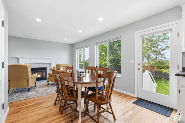 Wood-finish flooring, recessed lighting, fireplace with a painted mantel, and glass-paneled exterior door