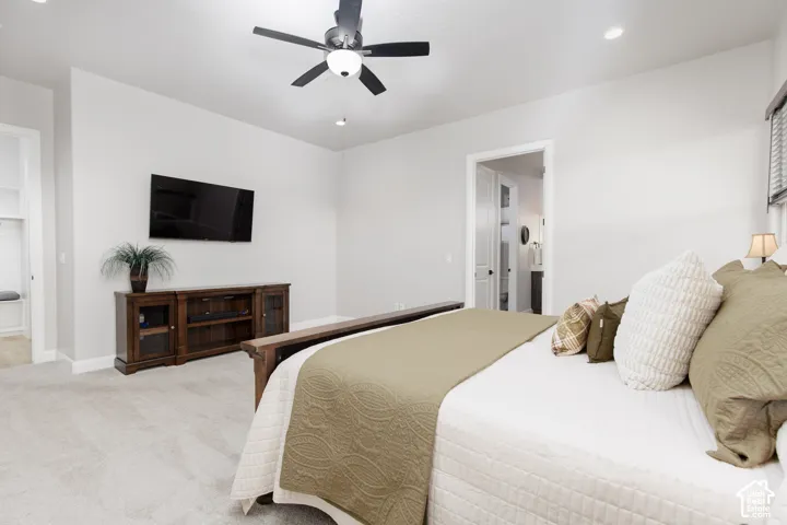 Neutral-toned interior space featuring high ceilings, wall-to-wall carpeting, recessed lighting, and a multi-blade ceiling fan with an integrated light fixture