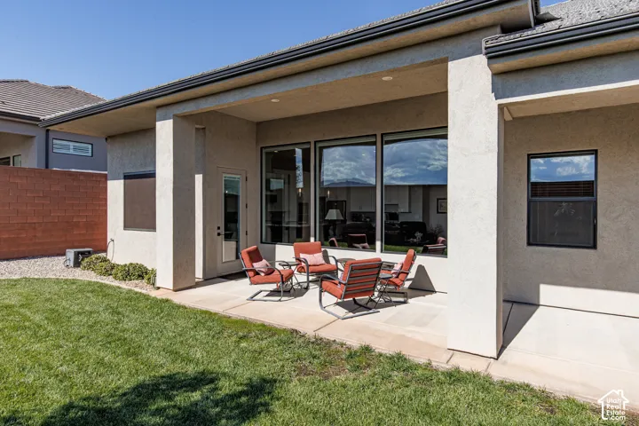 Covered concrete patio featuring recessed lighting, a smooth stucco exterior, and large multi-panel windows