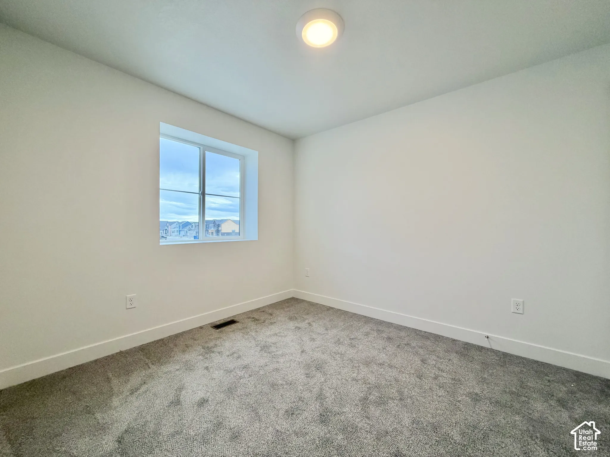 Interior space featuring neutral wall tones, plush wall-to-wall carpeting, and a flush-mount ceiling light fixture