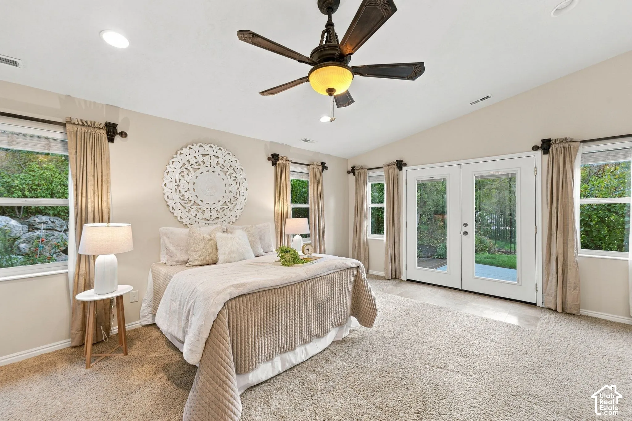 Vaulted ceilings, multi-light glass paneled exterior doors, and neutral wall-to-wall carpeting