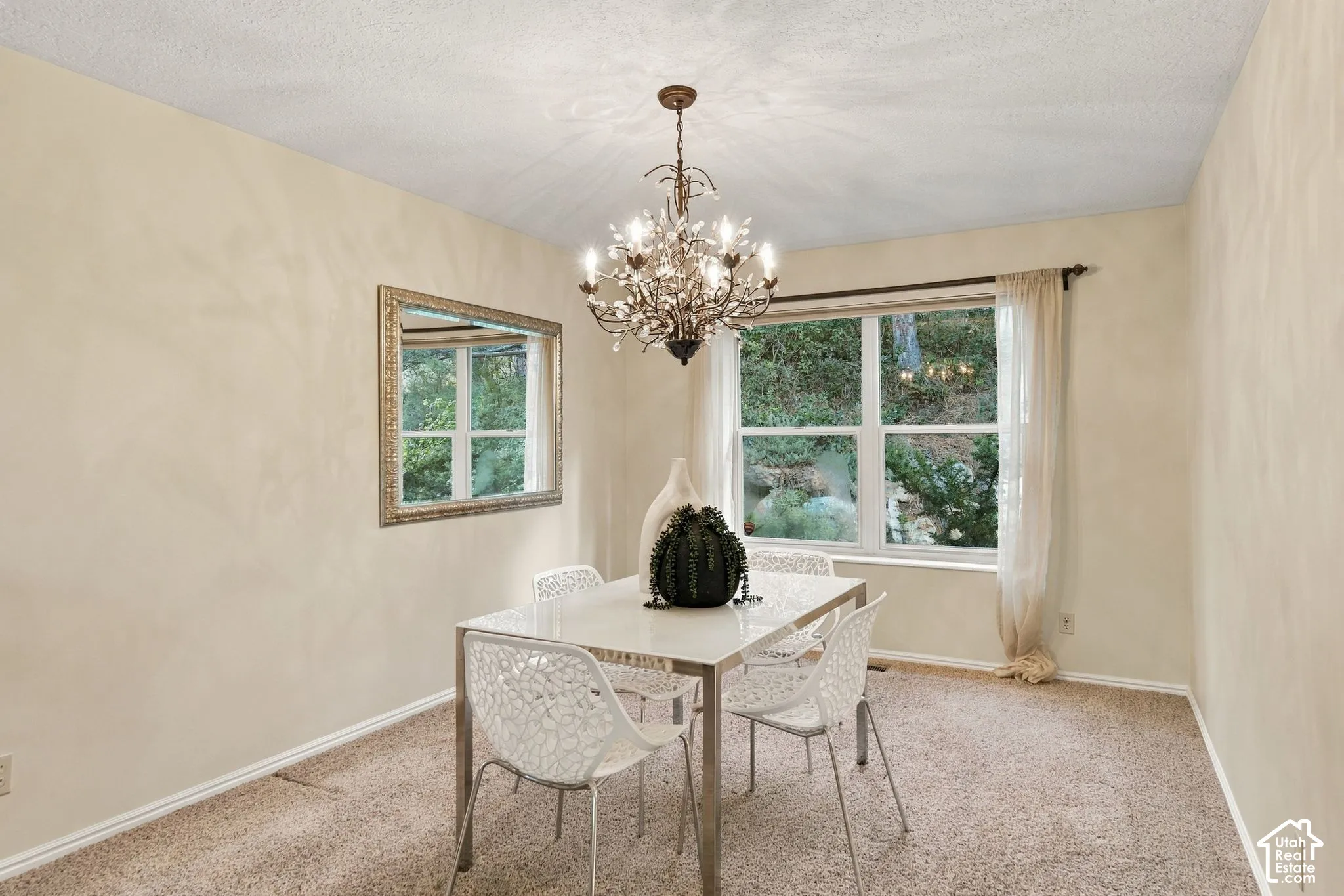 Multi-arm chandelier, large-format window, and decorative wall-mounted mirror