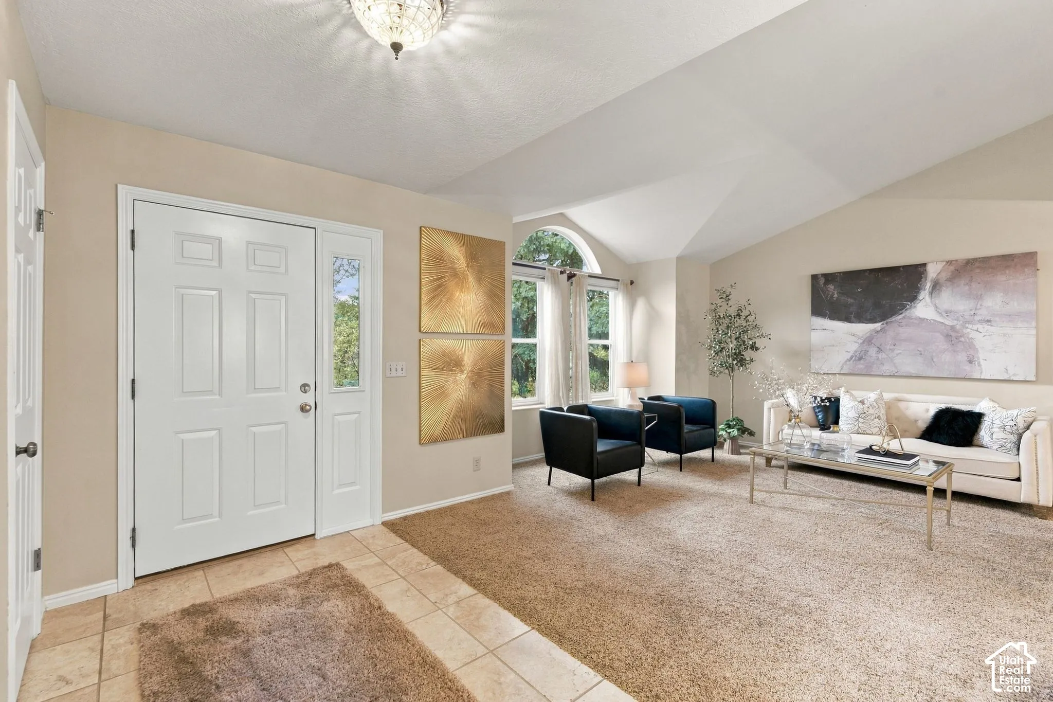 Entryway featuring tile flooring, vaulted ceilings, arched window, and flush-mount lighting