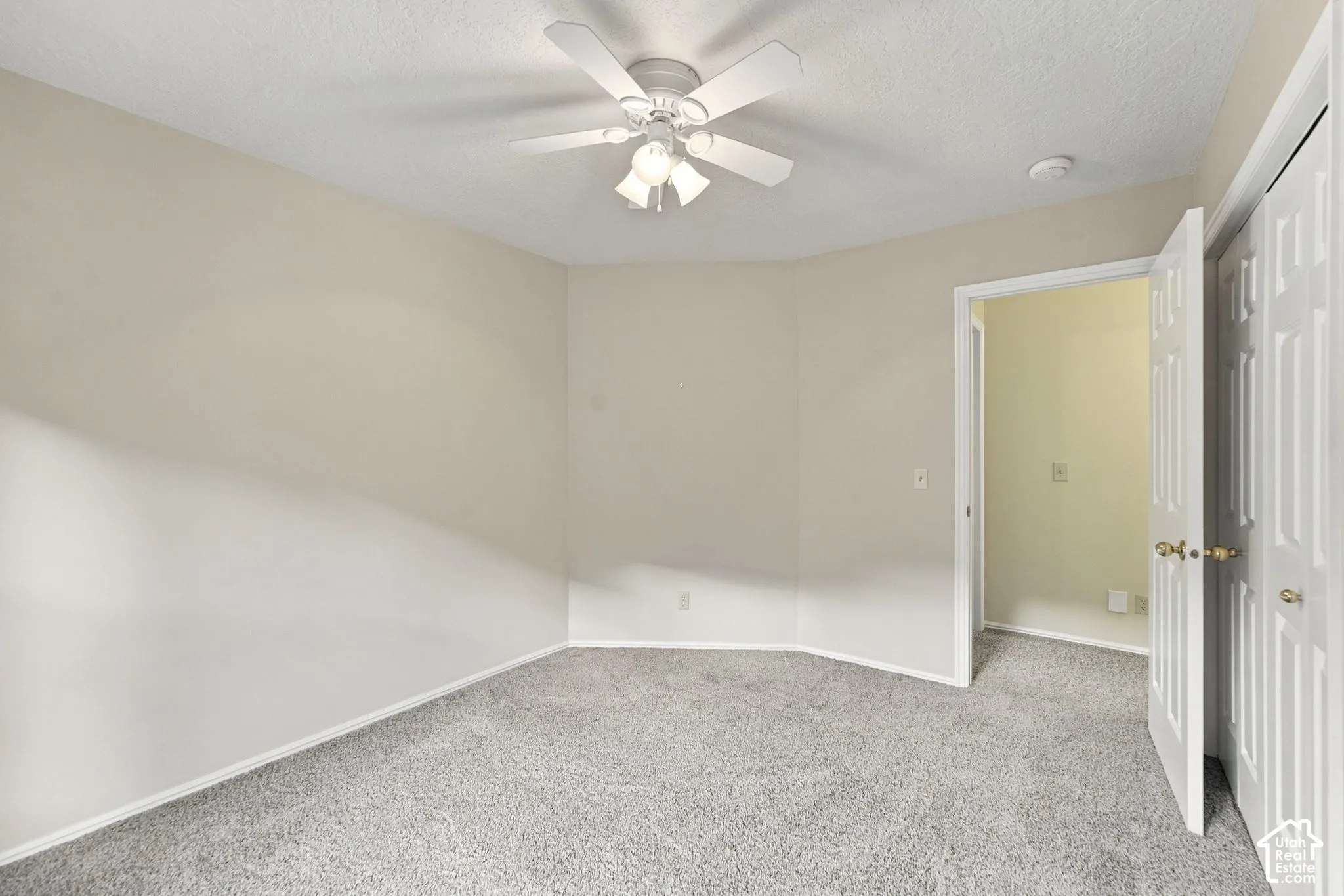Neutral wall palette featuring carpeted flooring, a ceiling fan with multi-bulb lighting, and six-panel closet doors