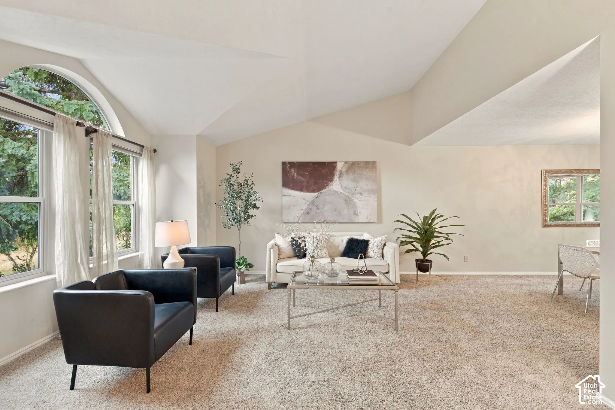 Vaulted ceilings, arched picture window, and neutral wall tones