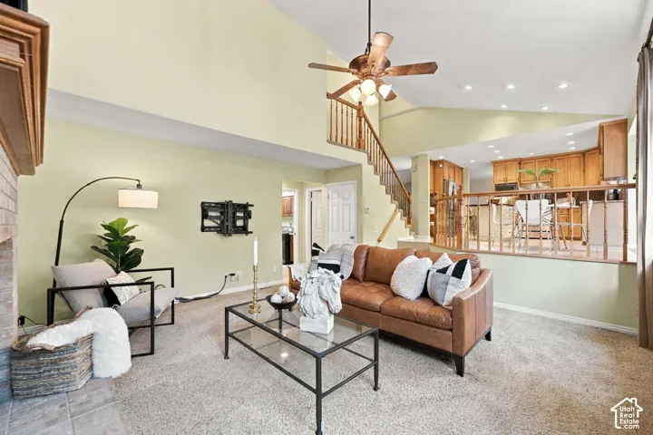 Vaulted ceilings, brick-surround fireplace, and wooden staircase railing with spindle balusters
