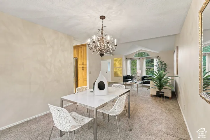 Vaulted ceilings with an arched window, decorative multi-tiered crystal chandelier, and built-in floor-to-ceiling wooden cabinetry