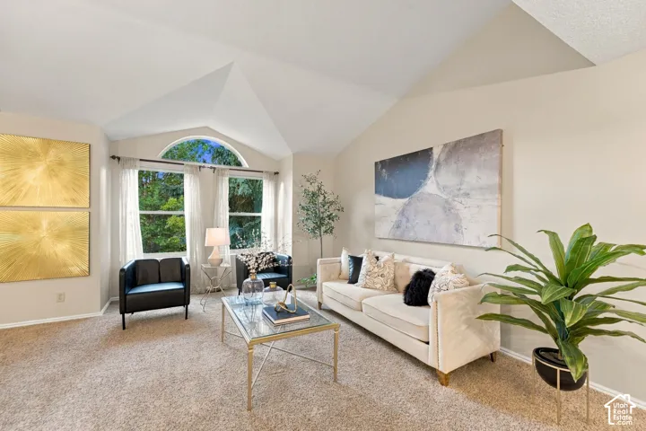 Vaulted ceilings, neutral wall tones, and large windows featuring an arched top transom