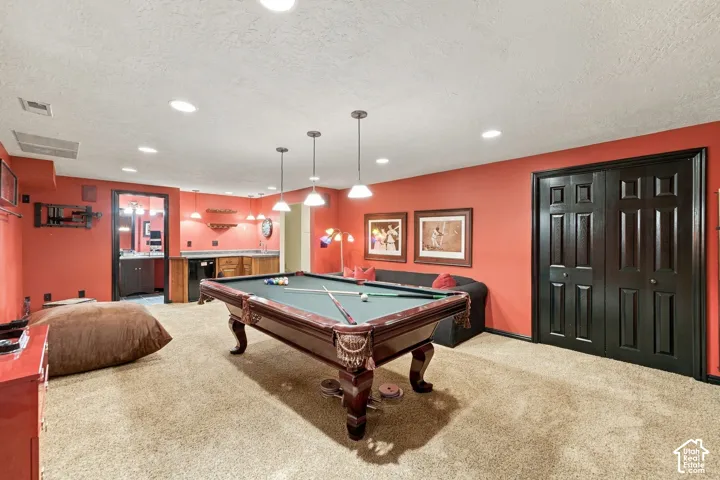 Interior room featuring a built-in wet bar with cabinetry, pendant lighting, recessed ceiling lights, and double doors with dark finish hardware