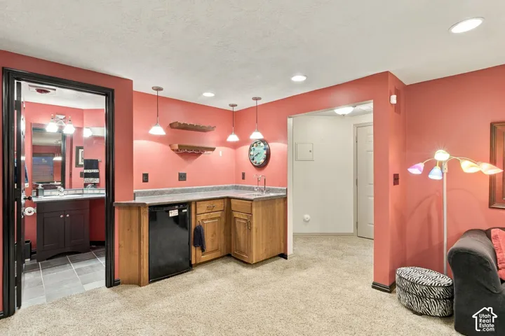 Wet bar featuring wooden cabinetry, laminate countertops, a built-in under-counter refrigerator, and pendant lighting