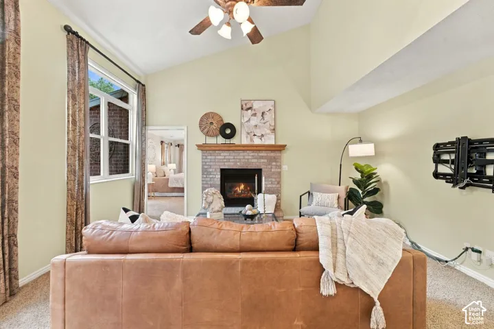 Vaulted ceilings, brick fireplace with a wood mantel, and large windows