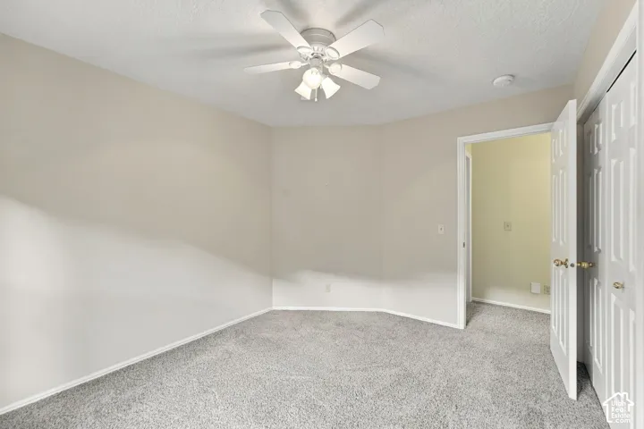 Neutral wall palette featuring carpeted flooring, a ceiling fan with multi-bulb lighting, and six-panel closet doors