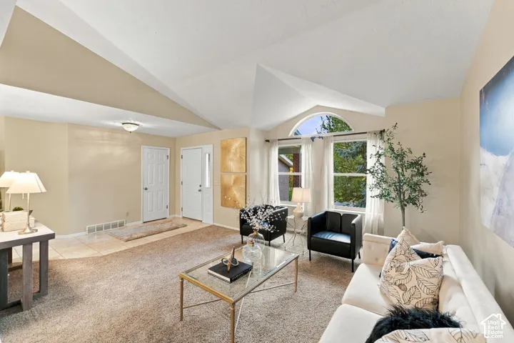 Vaulted ceilings, arched window accent, and recessed ceiling lighting